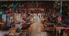 the inside of a market with lots of items on display and people walking through it