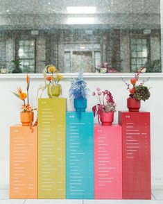 colorful flower pots on top of each other in front of a window