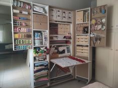 a sewing room with lots of crafting supplies on shelves and shelving units in it