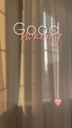 a window with the words good morning written on it and a pink heart hanging in front