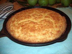 a skillet with some food in it sitting on a table next to green apples