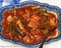 a blue and white plate topped with meat and veggies covered in gravy