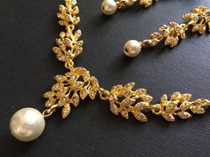 "** This listing including a necklace with a matching earrings (studs at back design). ** Romantic shaped gold plated necklace featuring clear rhinestones crystals and dangly with pearls at bottom. Perfect for your wedding wear!! Size: necklace measures around 15\" long x 1.45\" center drop. Earrings around 3\" long x 0.5\"width Color: gold with clear rhinestone crystals and pearls Item ship out in a gift box with tracking number to you (around 10 to 14 business days for delivery). We also provi Gold Rhinestone Crystal Necklace For Wedding, Elegant Gold Rhinestone Necklace For Wedding, Gold Rhinestone Necklaces For Wedding, Gold Rhinestone Jewelry Sets For Anniversary, Gold Rhinestone Necklace For Wedding, Gold Bridal Necklace With Rhinestones For Wedding, Elegant Gold Jewelry Sets With Rhinestones, Bridal Necklace Gold, Chandelier Necklace