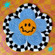 a blue and black flower with a smiley face drawn on it's center piece