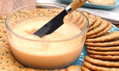 a cracker is being used to spread peanut butter on crackers in a glass bowl