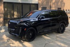 a black suv parked in front of a building