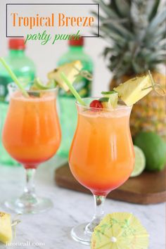 tropical breeze party punch in glasses with pineapple garnish on the rims