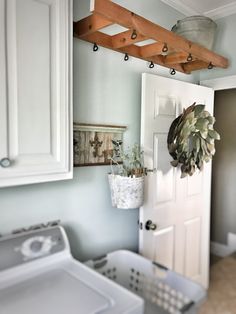 a washer and dryer in a laundry room next to a door with hooks on it