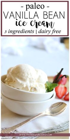 a bowl filled with vanilla ice cream next to a spoon and strawberries on the side