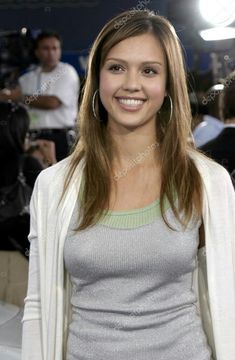 a beautiful young woman standing in front of a camera