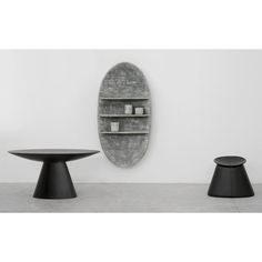 three black tables and one round table in front of a white wall with a mirror on it