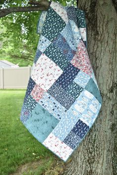 a blue and red quilt hanging from a tree