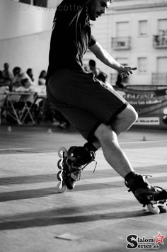 a man riding a skateboard down the side of a street next to a crowd