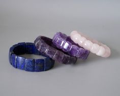 "A lovely amethyst stretch bracelet. Polished natural amethyst stones of vibrant purple color, strung on a double elastic. The bracelet will be shipped in a gift box. Amethyst, which is known as a birthstone of February, is believed to be a meditative and calming stone which works on the emotional, spiritual, and physical levels to provide calm, balance, patience, and peace. Amethyst beads measure over 3/5\" by 1/2\" (1.6 cm x 1.2 cm) Internal diameter of the bracelet is about 2 1/6\" (5.5 cm) - Adjustable Purple Stretch Bracelet With Natural Stones, Spiritual Purple Crystal Bangle Bracelet, Spiritual Purple Stackable Bracelets, Spiritual Purple Stackable Bracelet, Purple Stretch Bracelet With Natural Stones, Purple Bangle Bracelet With Natural Stones, Purple Natural Stones Stretch Bracelet, Purple Amethyst Stretch Bracelet With Natural Stones, February Gemstone