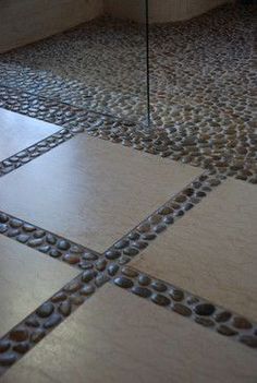 the bathroom floor is made out of stone and has an interesting design pattern on it