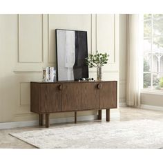 a wooden cabinet with two drawers and a plant on top in front of a window