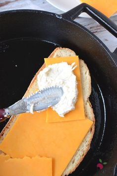 a sandwich with cheese and butter in a pan