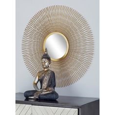 a buddha statue sitting in front of a mirror on top of a dresser next to a white wall