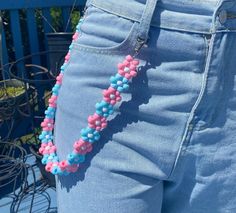 a woman's blue jean shorts with pink and blue beads