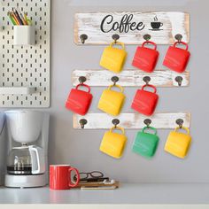 a coffee cup holder is hanging on the wall next to a mug rack with cups