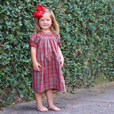 Create joyful memories with our Merry and Bright Plaid Smocked Dress. This green and red plaid dress is the perfect choice for your Christmas celebration. The dress features delightful geometric smocking and elegant bishop sleeves adorned with red ric-rac trim. Plaid Christmas Holiday Dress, Plaid Dresses For Fall Holiday, Fitted Plaid Smocked Dress With Smocked Bodice, Fitted Plaid Smocked Dress, Red Smocked Back Dress For Fall, Red Smocked Bodice Dresses For Fall, Red Dress With Smocked Back For Fall, Red Dress With Smocked Bodice For Fall, Red Dresses With Smocked Bodice For Fall