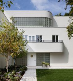 a white house with lots of windows and grass