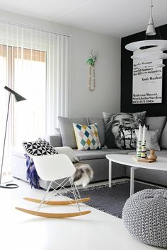 a living room with grey couches and white table in front of the large window