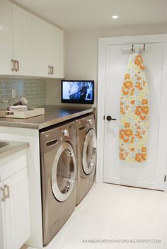 a washer and dryer in a small room with a television on the wall