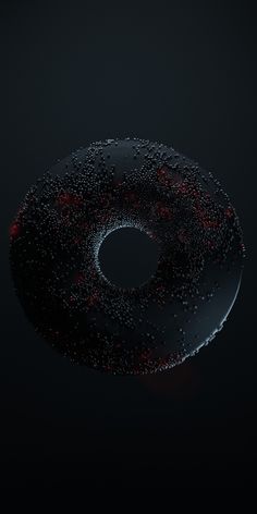 a donut covered in water droplets on a black surface with red dots around it