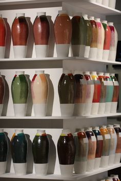 many different vases are displayed on the shelves