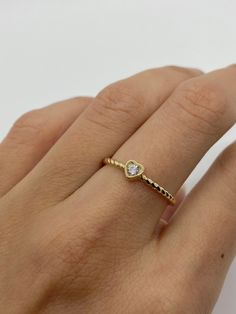 This beautiful heart 🤍ring 💍features a bezel set cubic zirconia stone with a twisted band detail on the sides. A simple, elegant ring great for wearing every day. * Solid 14K gold * AAAA quality CZ stone * Bezel set setting Visit us on Instagram @agoldmindjewelry for our custom jewelry designs and newest listings ▬ All jewelry pieces are sent in a gift box ▬ Our shipping and return policies: ~ Items will be shipped Free via USPS First Class Mail. We gladly accept returns, exchanges, and cancel Heart Ring With Bezel Setting For Promise, Stackable Heart Ring For Everyday And Valentine's Day, Everyday Stackable Heart Ring For Valentine's Day, Valentine's Day Dainty Heart Ring With Diamond Accents, Valentine's Day Heart Ring With Single Diamond, Valentine's Day Heart-shaped Rings With Bezel Setting, Beaded Heart Ring, Band Valentines, Ring Twisted Band