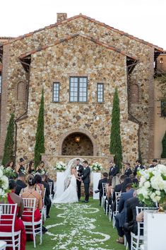 a bride and groom are walking down the aisle