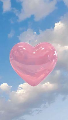 a pink heart shaped balloon floating in the sky