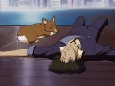 a man laying on the ground next to a brown and white corgi dog