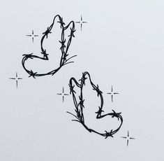 barbed wire on the side of a white wall with cross marks in it and two birds