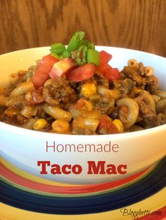 a white bowl filled with taco macaroni and cheese on top of a colorful plate