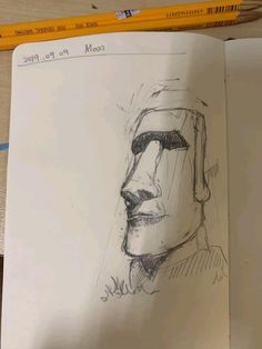 a drawing of a man's face is shown in this sketching book with pencils next to it