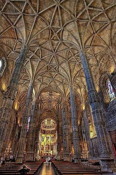 the inside of a cathedral with pews and stained glass windows