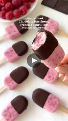 a person is holding a chocolate raspberry popsicle over marshmallows