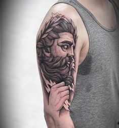 a man's arm with a black and white tattoo of a bearded man holding a pipe