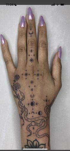 a woman's hand with an octopus tattoo on it and stars in the sky