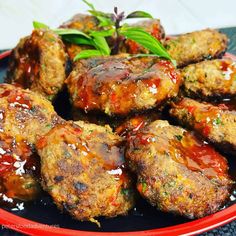 meatballs covered in sauce on a red plate