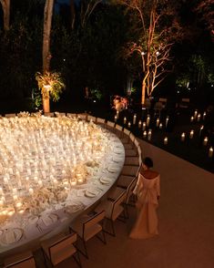 the table is set up with candles and place settings for an elegant wedding reception at night