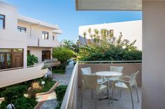 an apartment balcony with table and chairs