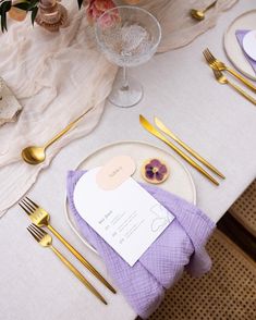 a table set with purple and gold place settings