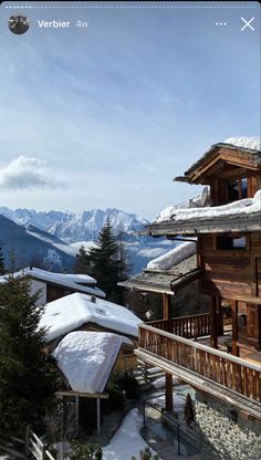 a snow covered building with mountains in the background