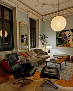 a living room filled with furniture and a painting on the wall next to a window