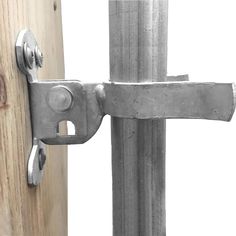 a close up of a metal door handle on a wooden post with a white background