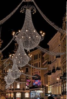 a city street filled with lots of lights and hanging decorations in the middle of it