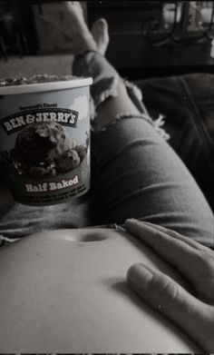 a cup of ice cream sitting on top of a person's stomach